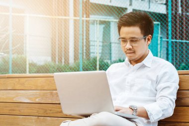 Genç işadamı Garden'da dizüstü bilgisayarda çalışma