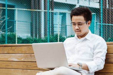 Genç işadamı Garden'da dizüstü bilgisayarda çalışma