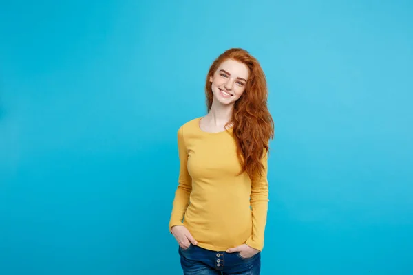 Ritratto di giovane bella donna rossiccia con lentiggini che sorridono allegramente guardando la macchina fotografica. Isolato su sfondo blu pastello. Copia spazio . — Foto Stock