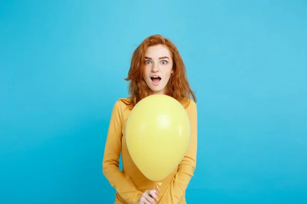 Primer plano Retrato feliz joven hermosa chica pelirroja atractiva sonriendo con globo de fiesta colorido. Fondo azul pastel . — Foto de Stock