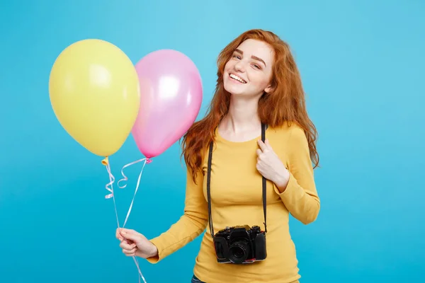 Estilo de vida y concepto de fiesta - Primer plano Retrato joven hermosa atractiva pelirroja chica de pelo rojo con globo de colores y cámara vintage. Fondo Pastel Azul. Copiar espacio . — Foto de Stock