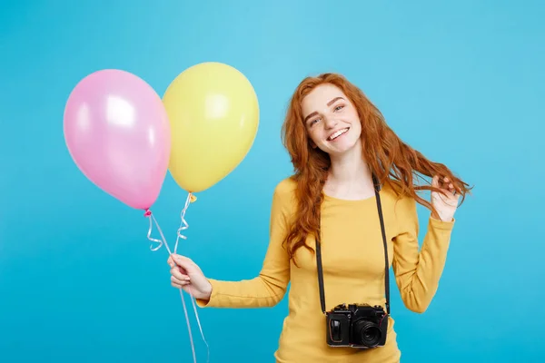 Estilo de vida y concepto de fiesta - Primer plano Retrato joven hermosa atractiva pelirroja chica de pelo rojo con globo de colores y cámara vintage. Fondo Pastel Azul. Copiar espacio . — Foto de Stock