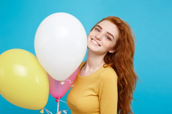 Primer plano Retrato feliz joven hermosa chica pelirroja atractiva sonriendo con globo de fiesta colorido. Fondo azul pastel . — Foto de Stock