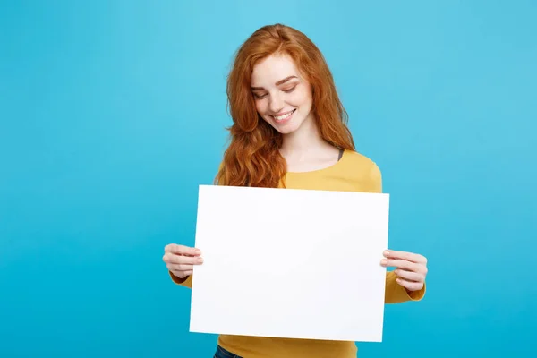 Close up Portrait young beautiful attractive ginger red hair girl smiling showing blank sign. Blue Pastel Background. Copy space. — Stock Photo, Image