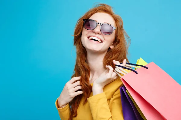 Shopping-Konzept - Nahaufnahme Porträt junge schöne attraktive Rothaarige lächelnd in die Kamera mit Einkaufstasche. blauer Pastellhintergrund. Kopierraum. — Stockfoto