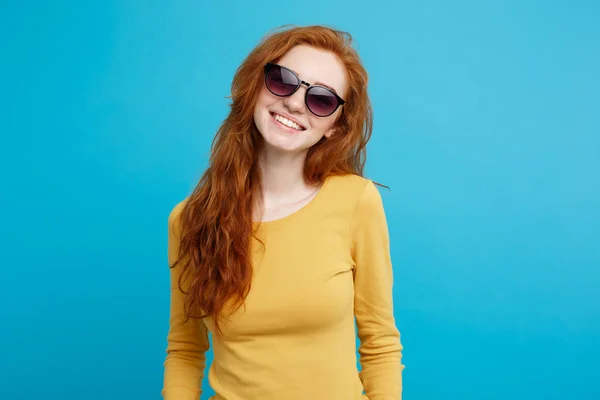 Concetto di viaggio - Close up Ritratto giovane bella bella ragazza capelli rossi zenzero con occhiali da sole alla moda sorridente. Sfondo blu pastello. Copia spazio . — Foto Stock