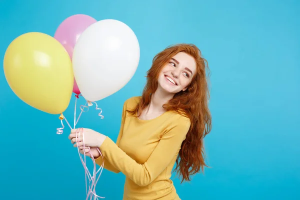 Primer plano Retrato feliz joven hermosa chica pelirroja atractiva sonriendo con globo de fiesta colorido. Fondo azul pastel . — Foto de Stock