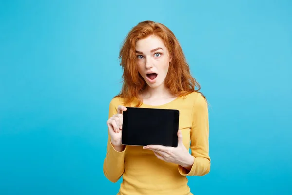 经营理念-特写肖像年轻美丽诱人 redhair 女孩微笑在黑色显示数字平板电脑屏幕。蓝色柔和的背景. — 图库照片