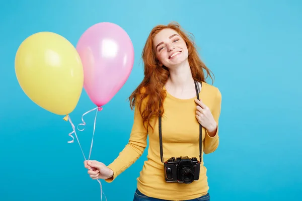 Estilo de vida y concepto de fiesta - Primer plano Retrato joven hermosa atractiva pelirroja chica de pelo rojo con globo de colores y cámara vintage. Fondo Pastel Azul. Copiar espacio . — Foto de Stock