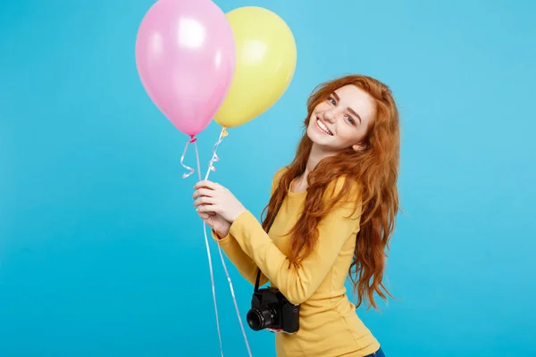 Estilo de vida y concepto de fiesta - Primer plano Retrato joven hermosa atractiva pelirroja chica de pelo rojo con globo de colores y cámara vintage. Fondo Pastel Azul. Copiar espacio . — Foto de Stock