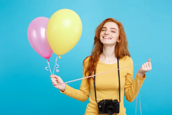 Estilo de vida y concepto de fiesta - Primer plano Retrato joven hermosa atractiva pelirroja chica de pelo rojo con globo de colores y cámara vintage. Fondo Pastel Azul. Copiar espacio . — Foto de Stock