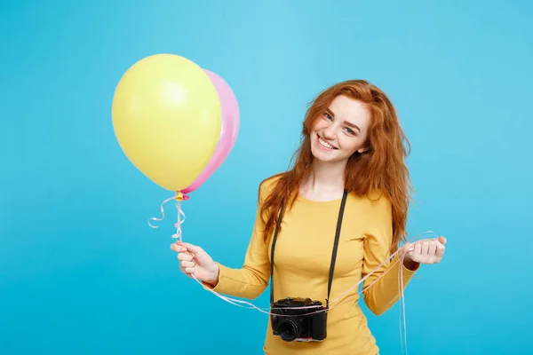 Estilo de vida y concepto de fiesta - Primer plano Retrato joven hermosa atractiva pelirroja chica de pelo rojo con globo de colores y cámara vintage. Fondo Pastel Azul. Copiar espacio . — Foto de Stock