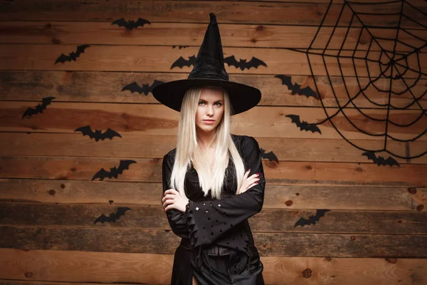 Conceito de bruxa de Halloween - Feliz Halloween Sexy Witch segurando posando sobre fundo velho estúdio de madeira . — Fotografia de Stock