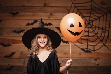Halloween cadı kavramı - küçük beyaz cadı çocuk Cadılar Bayramı balon ile keyfini çıkarın. yarasa ve örümcek web arka plan üzerinde.
