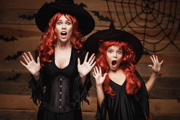 Хэллоуин - мать и ее дочь с длинными рыжими волосами в париках с шокированным выражением лица . — стоковое фото