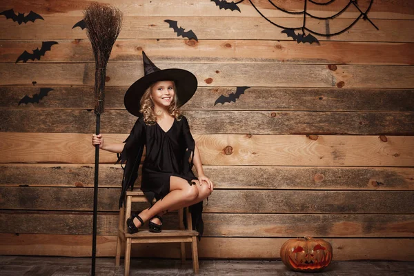 Halloween cadı kavramı - sihirli süpürgesine yarasa ve örümcek web arka plan üzerinde poz küçük beyaz cadı çocuğun tam uzunlukta atış. — Stok fotoğraf