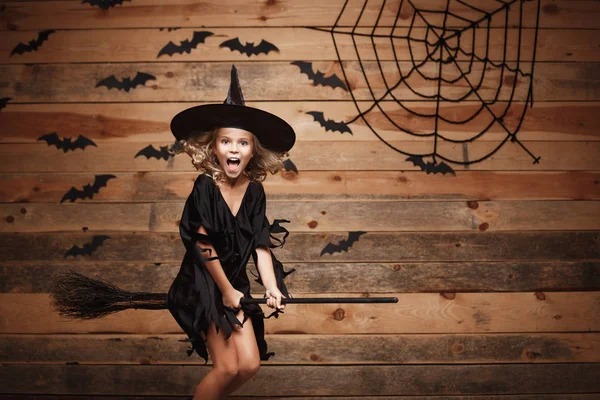 Halloween cadı kavramı - sihirli süpürge sopası ve örümcek web arka plan üzerinde uçan küçük beyaz cadı çocuk. — Stok fotoğraf