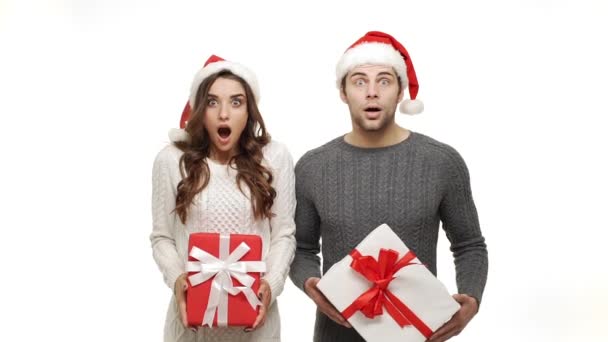 スローモーション若いカップル意外にもセーターを着て、クリスマスの帽子のショックはクリスマスの日に祝う. — ストック動画