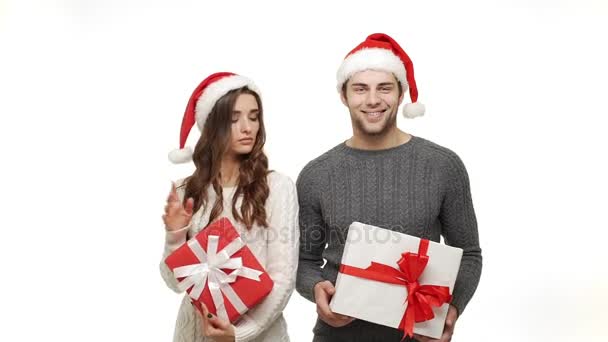 スローモーションのセーターで若いカップルが現在と踊りを楽しむクリスマス楽しみのため一緒に感じて魅力を祝う. — ストック動画