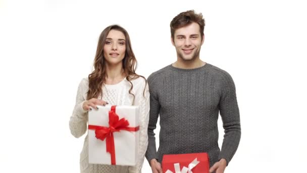 4k Pareja joven mostrando regalos en el día de Navidad sobre fondo blanco . — Vídeos de Stock