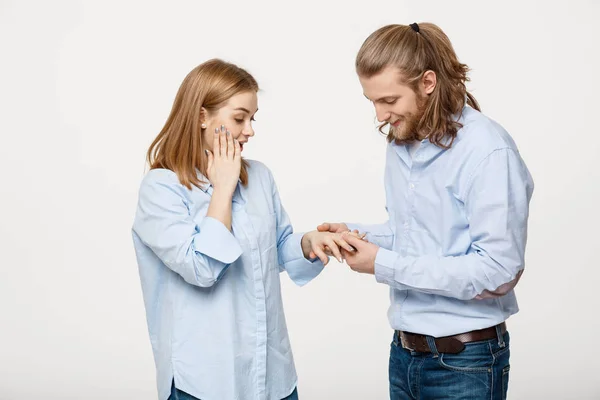 Portret wesoły przyjemność przystojny mężczyzna nosi pierścionek zaręczynowy za jej dziewczyna na na białym tle — Zdjęcie stockowe