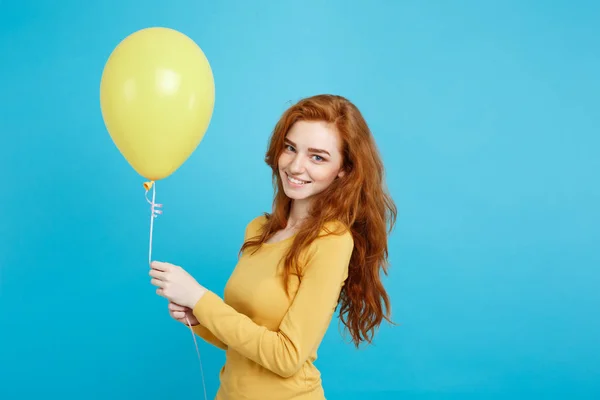 Celebrando Concepto - Primer plano Retrato feliz joven hermosa chica pelirroja atractiva sonriendo con globo de fiesta colorido. Fondo azul pastel . — Foto de Stock