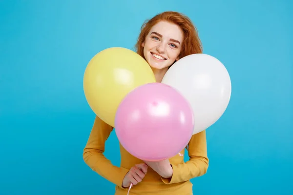 Celebrando Concepto - Primer plano Retrato feliz joven hermosa chica pelirroja atractiva sonriendo con globo de fiesta colorido. Fondo azul pastel . — Foto de Stock