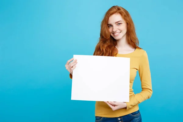 Business Concept -Close up Portrait young beautiful attractive ginger red hair girl smiling showing blank sign. Blue Pastel Background. Copy space. — Stock Photo, Image