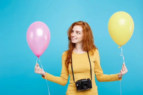 Estilo de vida y concepto de fiesta - Primer plano Retrato joven hermosa atractiva pelirroja chica de pelo rojo con globo de colores y cámara vintage. Fondo Pastel Azul. Copiar espacio . — Foto de Stock