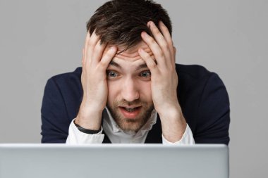 İş kavramı - portre yakışıklı stresli iş adamı iş laptop arıyorum takım elbise şoka girmiş. Beyaz arka plan.