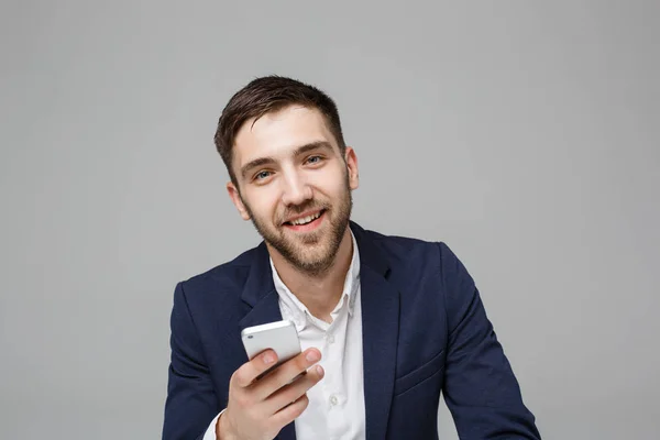 Geschäftskonzept - Porträt gut aussehender, gut aussehender Geschäftsmann im Anzug, der Mobiltelefon spielt und im Büro mit Laptop lächelt. weißer Hintergrund. — Stockfoto