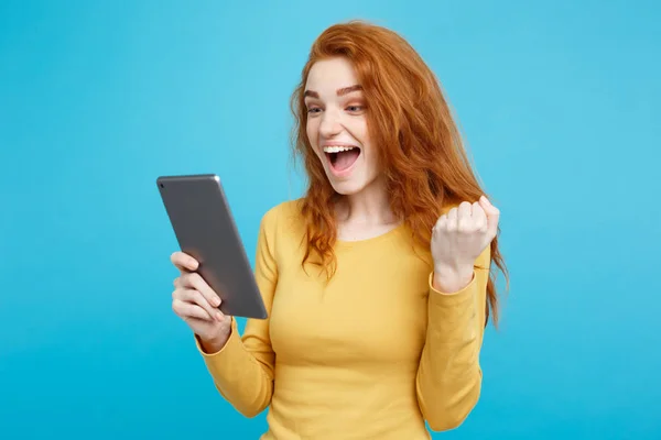 Närbild porträtt unga vackra attraktiva anbud ingefära redhair flicka glad leende på digitala bord med vinnande något. Blå pastell bakgrund. Kopiera utrymme. — Stockfoto