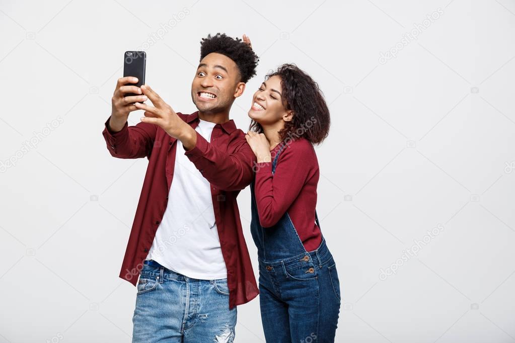 Young attractive African American Couple Pose For selfie pose with smart phone