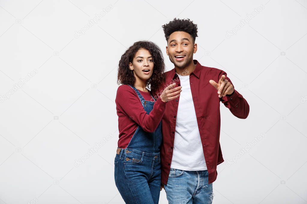 Young African American people in casual clothes looking away and point finger. isolated on white background