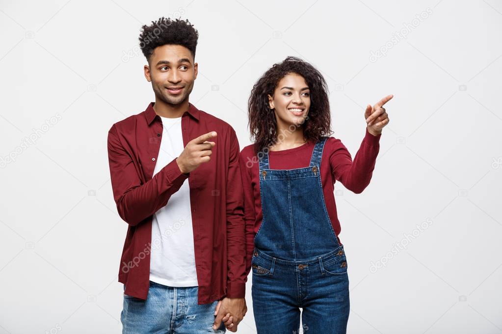 Young African American people in casual clothes looking away and point finger. isolated on white background