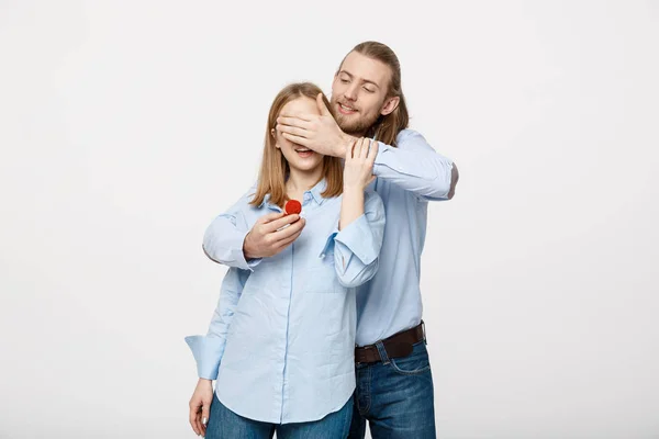 Retrato del hombre de barba guapo escondiendo los ojos de sus esposas para ofrecerle un anillo de compromiso para una propuesta de matrimonio —  Fotos de Stock