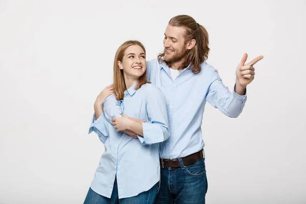 Πορτρέτο νέοι ευτυχισμένο ζευγάρι αγάπη χαμογελώντας Αγκαλιάζοντας το σημείο το δάχτυλό κενό αντίγραφο χώρου, άνδρας και γυναίκα χαμόγελο κοιτώντας ψηλά, απομονωμένα σε λευκό φόντο — Φωτογραφία Αρχείου