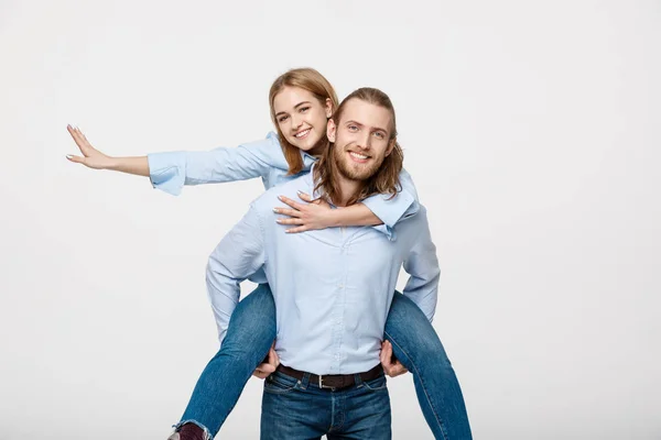 Retrato del hombre sonriente dando a la mujer feliz un paseo a cuestas . —  Fotos de Stock