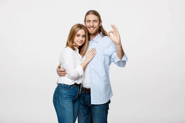 Šťastný mladý pár dělají ok gesto, izolovaných na bílém pozadí — Stock fotografie