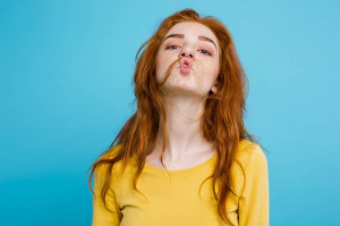Komik surat kameraya bakarak mutlu Kızıl kızıl saçlı kızla headshot portresi. Pastel mavi arka plan. Kopya alanı
