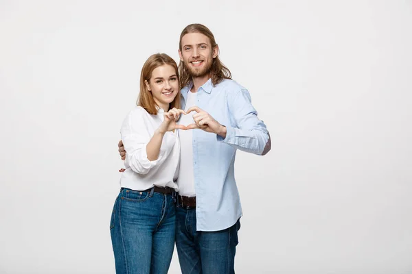 Pareja de San Valentín - retrato de la bella muchacha sonriente y su novio guapo haciendo forma de corazón por sus manos . —  Fotos de Stock