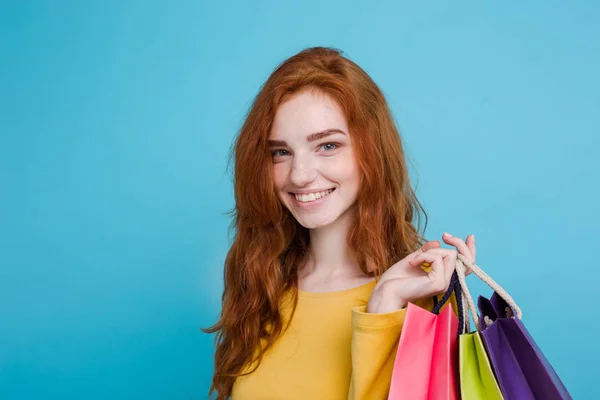 Nákupní koncept - zblízka portrét mladé krásné redhair atraktivní dívka, usmívající se, při pohledu na fotoaparát s nákupní taškou. Pastelové modré pozadí. Kopírovat prostor — Stock fotografie