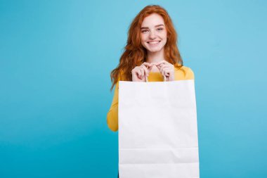 Alışveriş kavramı - portre genç güzel çekici Dişileştirilmiş kız kameraya Beyaz alışveriş çantası ile seyir gülümseyen yakından. Mavi Pastel renkli. Kopya alanı