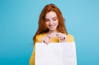 Alışveriş kavramı - portre genç güzel çekici Dişileştirilmiş kız kameraya Beyaz alışveriş çantası ile seyir gülümseyen yakından. Mavi Pastel renkli. Kopya alanı