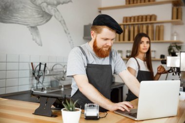 Kahve iş kavramı - sakallı genç yakışıklı bartende, barista veya Yöneticisi çalışma ve laptop modern kahve dükkanında planya.