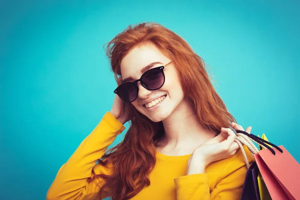 Nákupní koncept - zblízka portrét mladé krásné redhair atraktivní dívka, usmívající se, při pohledu na fotoaparát s nákupní taškou. Pastelové modré pozadí. Kopírovat prostor — Stock fotografie