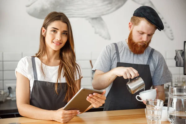 Coffee Business Concept - Baristas alegres olhando para seus tablets para pedidos on-line no café moderno . — Fotografia de Stock