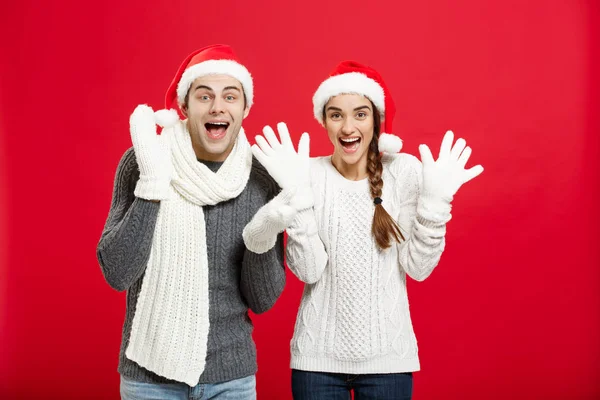 Retrato de um jovem casal feliz posando sobre fundo estúdio vermelho — Fotografia de Stock