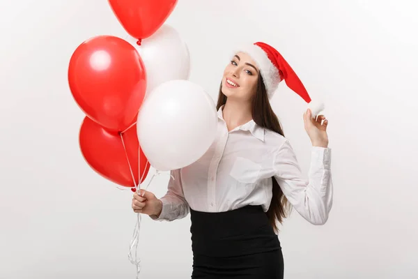 Conceito de negócio - Bela jovem mulher de negócios confiante com santa chapéu segurando balão celebrar para o Natal. — Fotografia de Stock