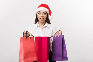 Noel kavramı - güzel beyaz iş kadını alışveriş çantasının içinde hediyeyle şok oldu..
